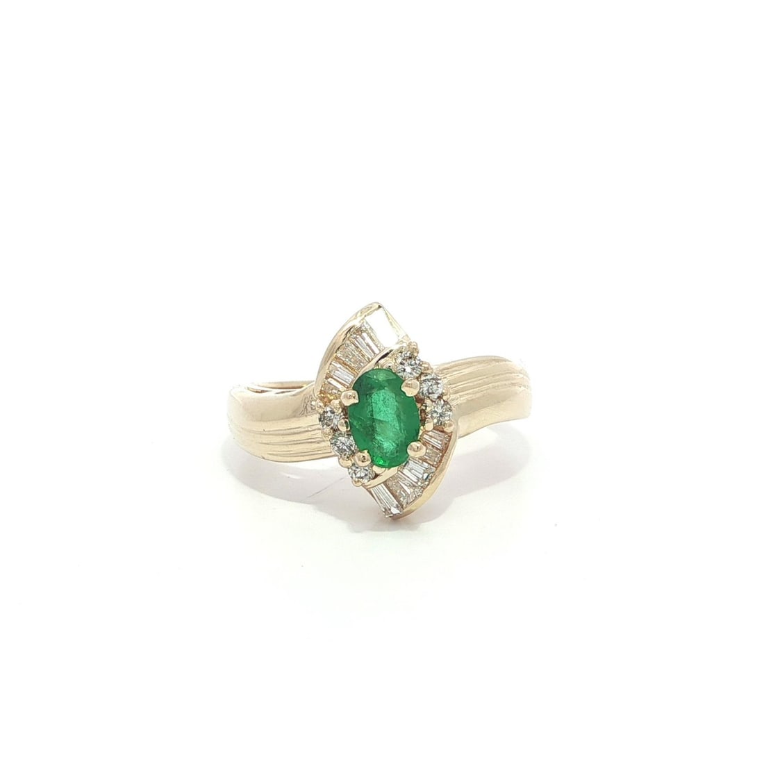 Oval Emerald and Diamond Baguette 14k Yellow Gold Grooved Cocktail Ring: Oval Emerald and Diamond Baguette 14k Yellow Gold Grooved Cocktail Ring This cocktail ring features a 0.52 carat natural oval-cut green emerald at its center, accented by 16 natural diamonds--6 round 