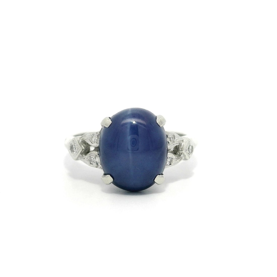 Vintage White Gold Cocktail Ring with Cabochon Blue Star Stone and Diamonds: Vintage White Gold Cocktail Ring with Cabochon Blue Star Stone and Diamonds This stunning vintage cocktail ring showcases a beautiful cabochon blue star stone set in solid white gold. The centerpiece 