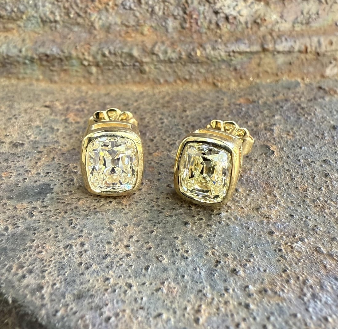 18k Yellow Gold GIA Certified Diamond Bezel Stud Earrings 2.13ctw: 18k Yellow Gold GIA Certified Diamond Bezel Stud Earrings 2.13ctw These elegant stud earrings feature two natural old mine cushion cut diamonds with a combined weight of 2.13 carats. Each diamond is b