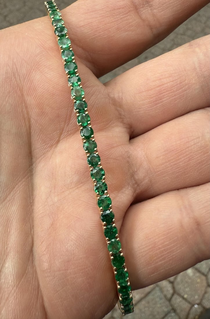 Emerald Tennis Bracelet 18k Yellow Gold 7.25 in Push Clasp: Emerald Tennis Bracelet 18k Yellow Gold 7.25 in Push Clasp This elegant tennis bracelet features 50 natural round brilliant cut emeralds with a total carat weight of 9.69, set in 18k solid yellow gold