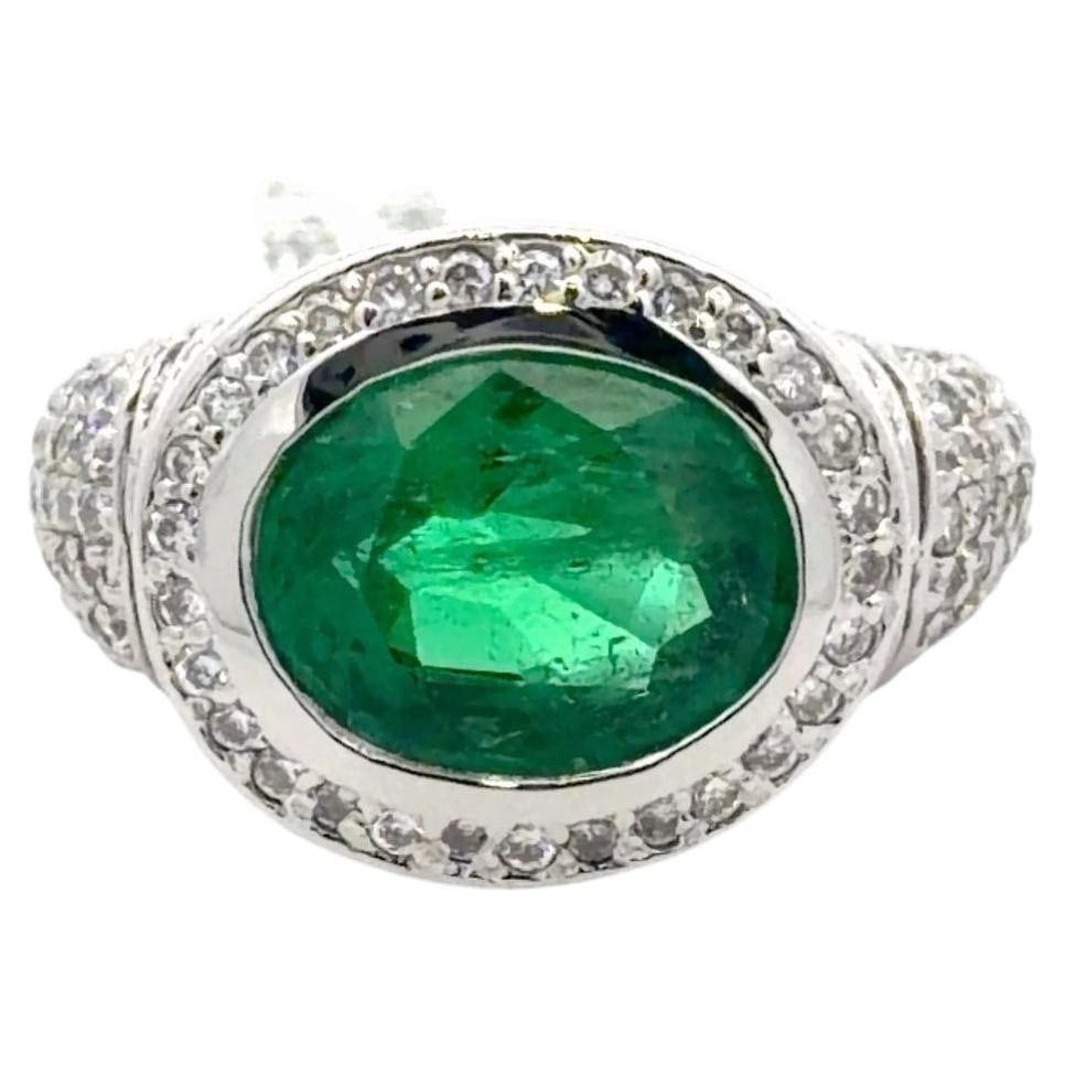 18K White Gold Cocktail Ring with 4.19 Carat Emerald and Diamond Halo: 18K White Gold Cocktail Ring with 4.19 Carat Emerald and Diamond Halo Contemporary cocktail ring featuring a 4.19 carat natural emerald in an east-west oval cut setting, surrounded by a diamond halo w