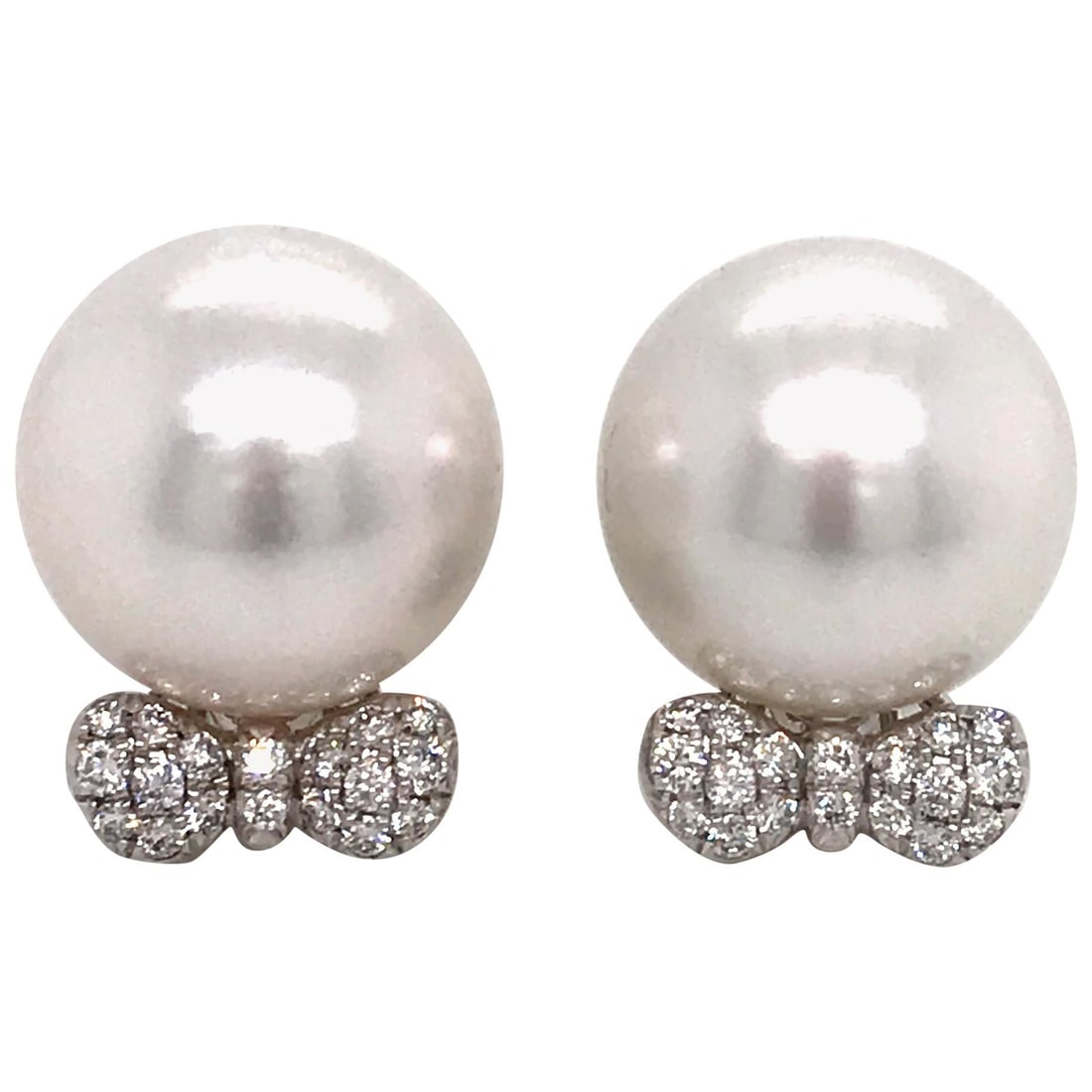 18K White Gold South Sea Pearl Bow Earrings with 0.36 Carat Diamonds: 18K White Gold South Sea Pearl Bow Earrings with 0.36 Carat Diamonds Contemporary 18K white gold earrings featuring a bow design set with round-cut diamonds and accented by two South Sea pearls. The b