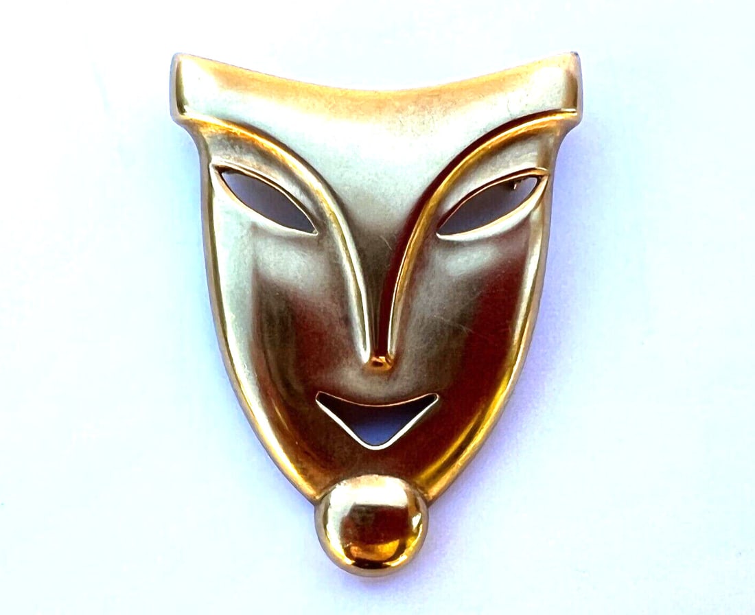 French Art Deco Mask Brooch in 18K Yellow Gold: French Art Deco Mask Brooch in 18K Yellow Gold French Art Deco mask brooch crafted in 18k yellow gold with a polished, sleek design. This pre-owned piece was purchased in Paris 50 years ago and featur