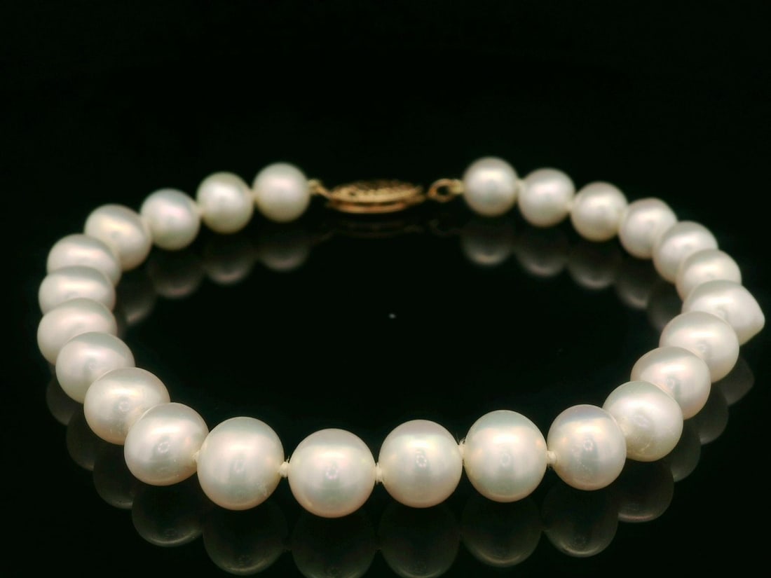 Natural 6-7mm Pearl Bracelet 14k Yellow Gold Clasp: Natural 6-7mm Pearl Bracelet 14k Yellow Gold ClaspThis elegant bracelet features a classic strand of genuine cultured pearls, each measuring 6-7mm in diameter. The pearls are round-shaped and showcase