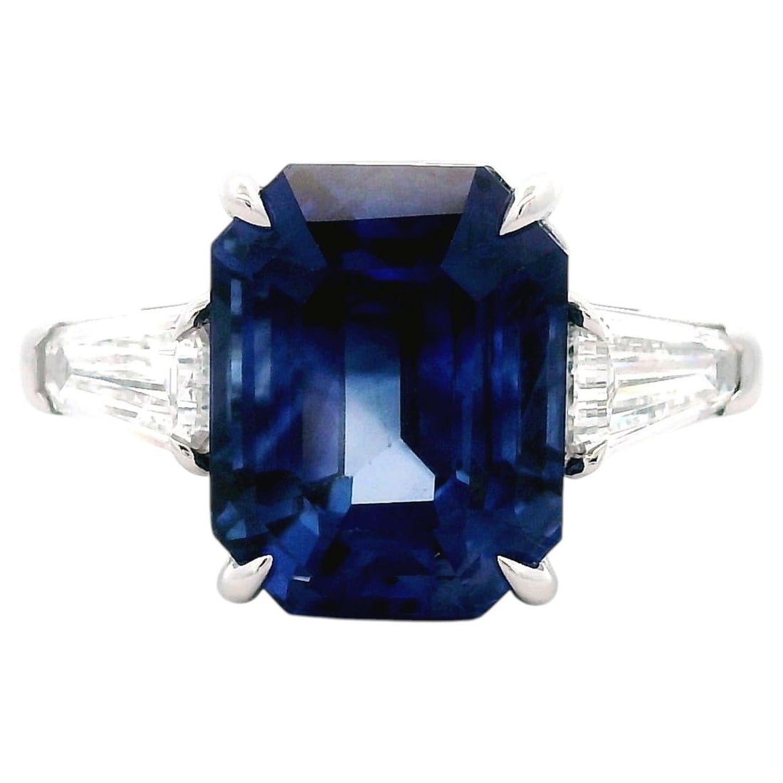 8.23ct Ceylon Sapphire Diamond 3 Stone Ring GIA: 8.23ct Ceylon Sapphire Diamond 3 Stone Ring GIA GIA-certified three-stone ring featuring a natural emerald cut Ceylon blue sapphire accented by two trapezoid diamonds. This contemporary ring is crafte