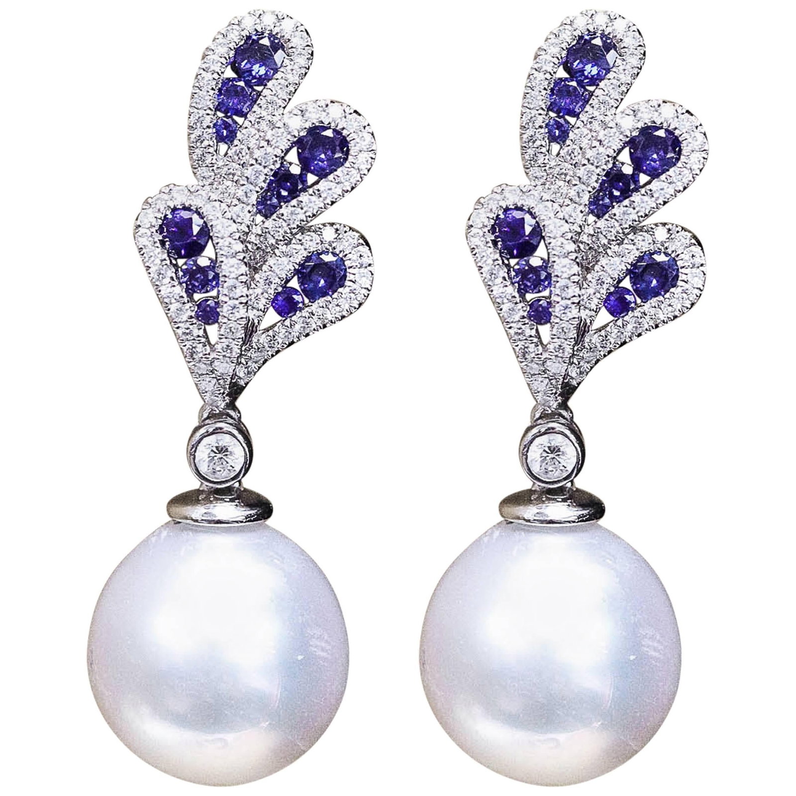 South Sea Pearl Drop Earrings in 18K White Gold with Sapphire and Diamond: South Sea Pearl Drop Earrings in 18K White Gold with Sapphire and Diamond Exquisite contemporary earrings crafted from 18k white gold, featuring stunning round cut sapphires, sparkling diamonds, and l