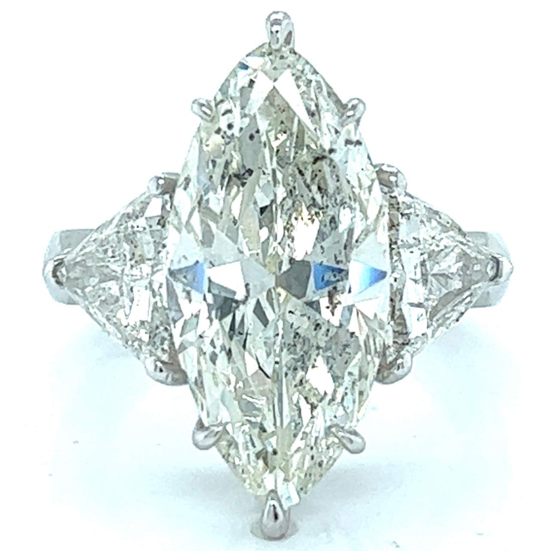 Platinum Ring 6.04 Ct Marquise Diamond K SI3 with 2 Diamonds: Platinum Ring 6.04 Ct Marquise Diamond K SI3 with 2 Diamonds This stunning platinum ring features a dazzling 6.04 Ct. marquise diamond at its center, showcasing a K color and SI3 clarity. The ring is 