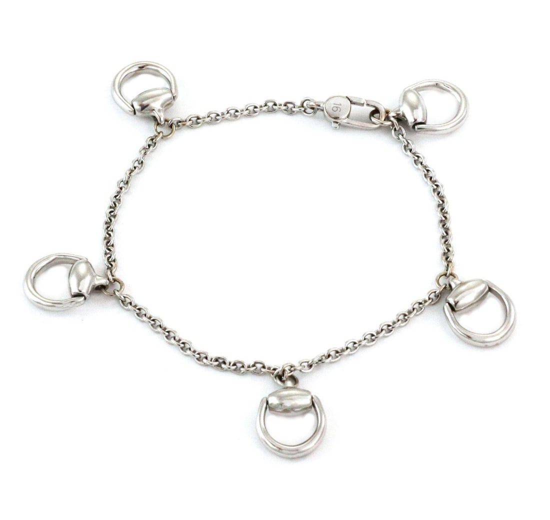 Gucci Horsebit Charm Bracelet in 18k White Gold with 5 Dangles: Gucci Horsebit Charm Bracelet in 18k White Gold with 5 Dangles This exquisite Gucci bracelet is a testament to luxury and craftsmanship, made from 18k white gold and adorned with five charming horsebi
