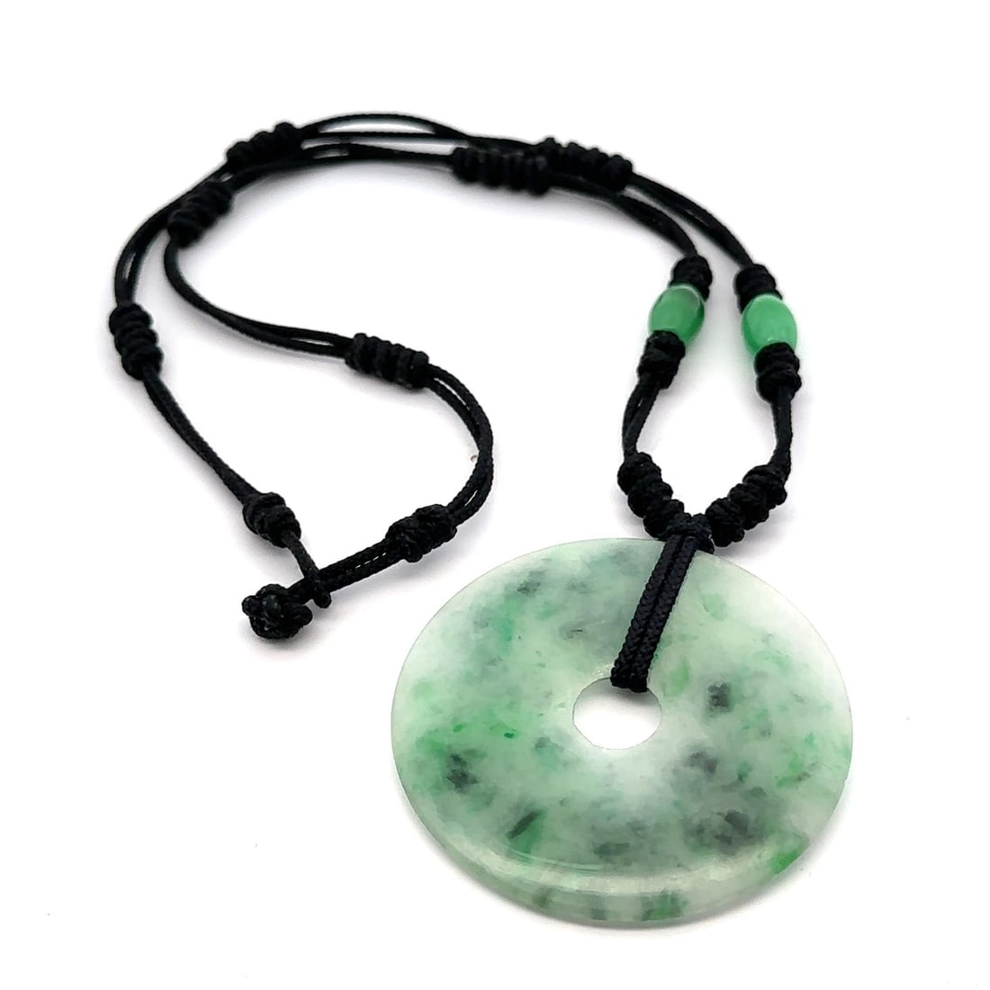Estate Green Jade Pendant Necklace on Adjustable Black Cord: Estate Green Jade Pendant Necklace on Adjustable Black Cord This elegant necklace features a stunning pendant crafted from natural green jade, shaped into a round disk with a mottled finish. The penda
