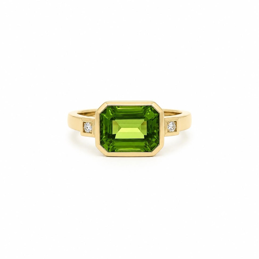 14k Yellow Gold Ring with Emerald Cut Peridot and 2 Diamonds: 14k Yellow Gold Ring with Emerald Cut Peridot and 2 Diamonds Pre-owned cocktail ring featuring a natural emerald-cut peridot set east-west in a bezel setting, accented by two natural round brilliant d
