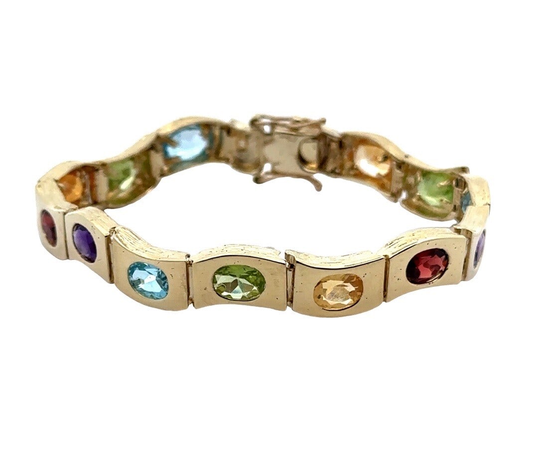 14K Yellow Gold Multi-Color Gemstone Wavy Line Bracelet: 14K Yellow Gold Multi-Color Gemstone Wavy Line Bracelet This exquisite 14K Yellow Gold Multi-Color Genuine Gemstone Bracelet showcases a stunning array of natural gemstones, including vibrant Blue
