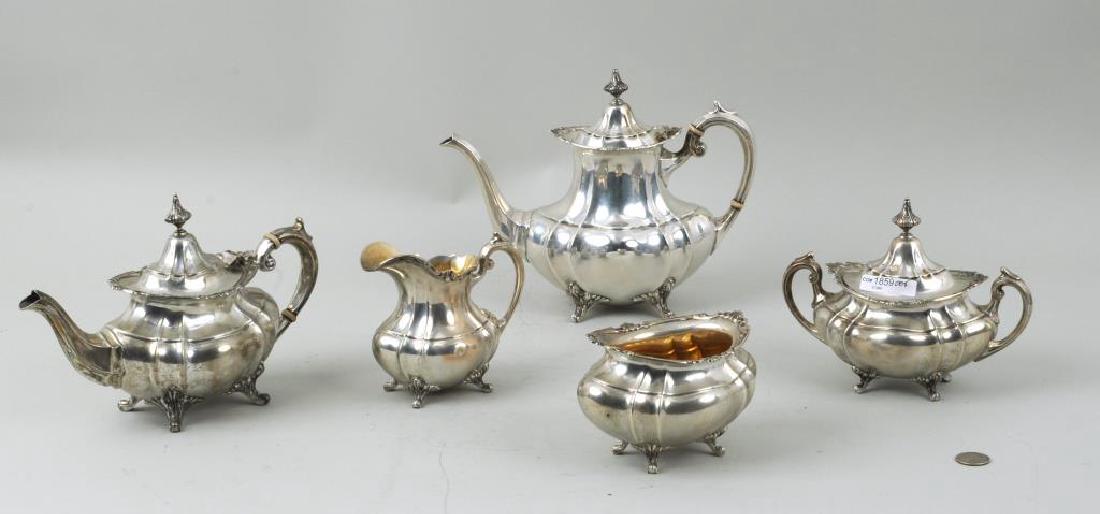 Reed & Barton Sterling Silver Tea & Coffee Service: Reed & Barton sterling silver tea and coffee service in the "Hampton Court" pattern comprising: teapot, coffee pot, covered sugar, creamer and waste bowl. Creamer, waste bowl with gilt interiors. A co