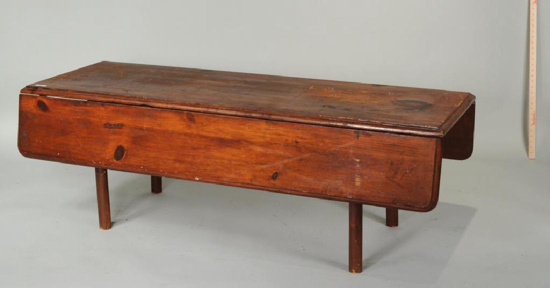 Country Pine Drop Leaf Coffee Table: Country pine drop leaf coffee table. Stains, scratches, wear with age, some marks "T"? 20" high, 59 1/2" wide, 24 1/2" long. Open: 38" long. Provenance: Estate of Richard S. Eckstrom, Guilford CT.