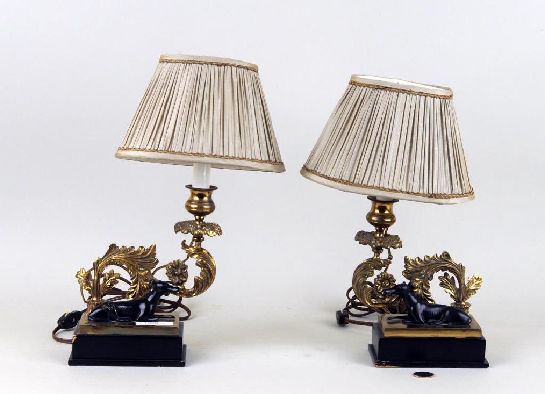 Pair Brass Whippet Form Desk Lamps: with recumbent hound and cast foliate candle arm on a stepped plinth. Losses to ebonized bases. 14" high, 3 1/2" wide, 5 1/2" deep. Provenance: A Fairfield CT Private Collection.