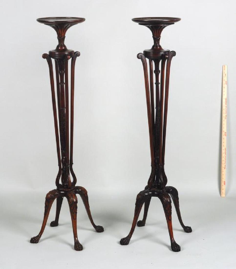 Pair Edwardian Carved Mahogany Torcheres: having circular tops, carved foliate detail and supported on a quadruped base on paw feet. Water stains and edge cracks to tops, scuffs and overall losses to feet. 51" high, 18 1/2" wide. Provenance: 