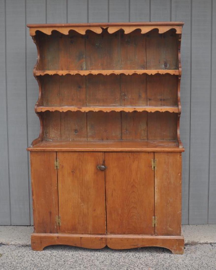 American Country Pine Pewter Cupboard: American Country Pine Pewter Cupboard having two shaped shelves over two cupboard doors. Use wear, finish wear, stains, loss to lower shelf at right edge, age cracks. 77" high, 31 1/2" wide, 17 1/2" d