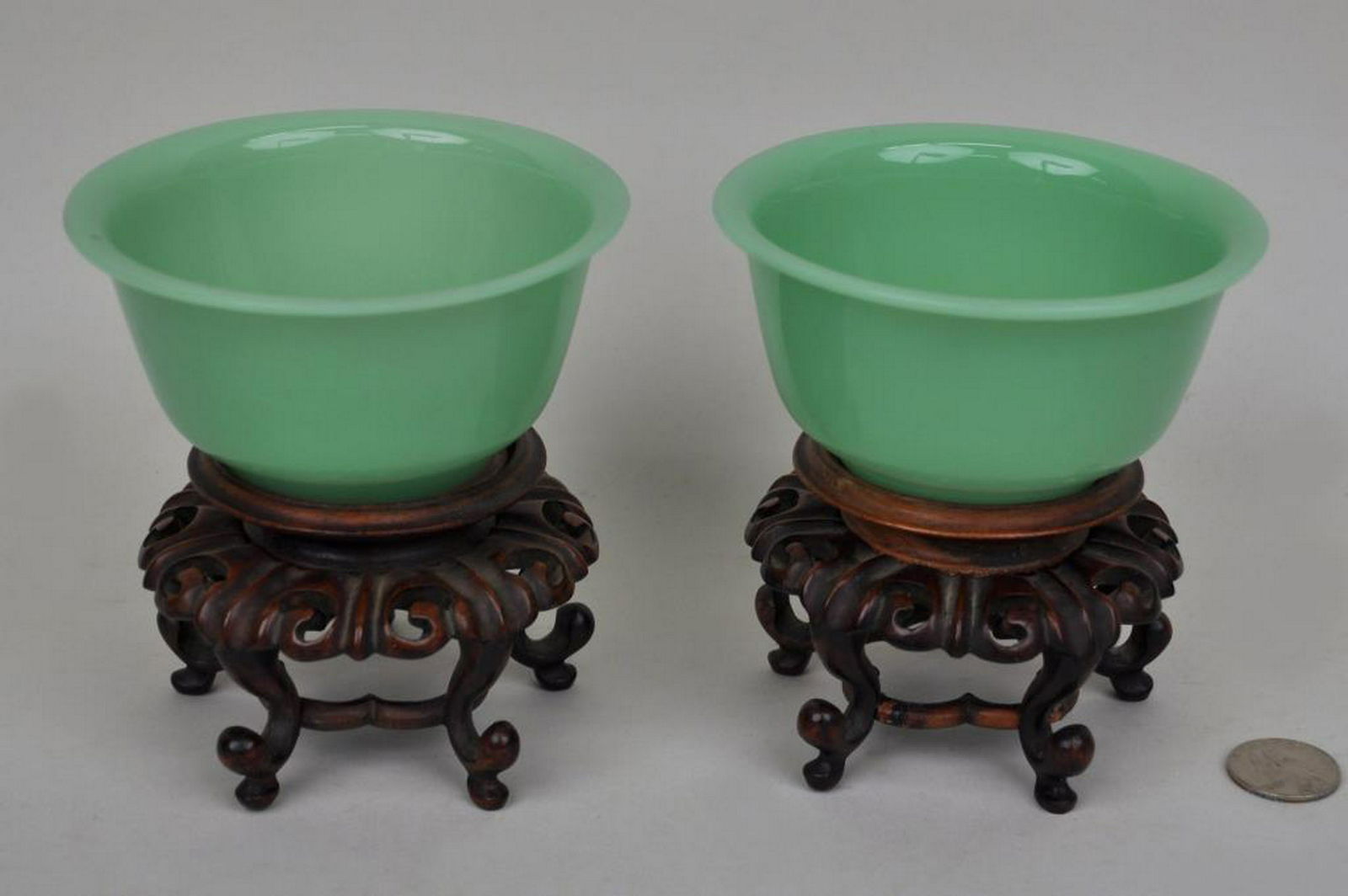Pair Chinese Light Green Glass Vases/Stands: likely Chen Dynasty. 4 3/4" high, 4 1/2" diameter. Glued to stands, one with crack encircling lower part of body, one stand with foot loss and old repairs.