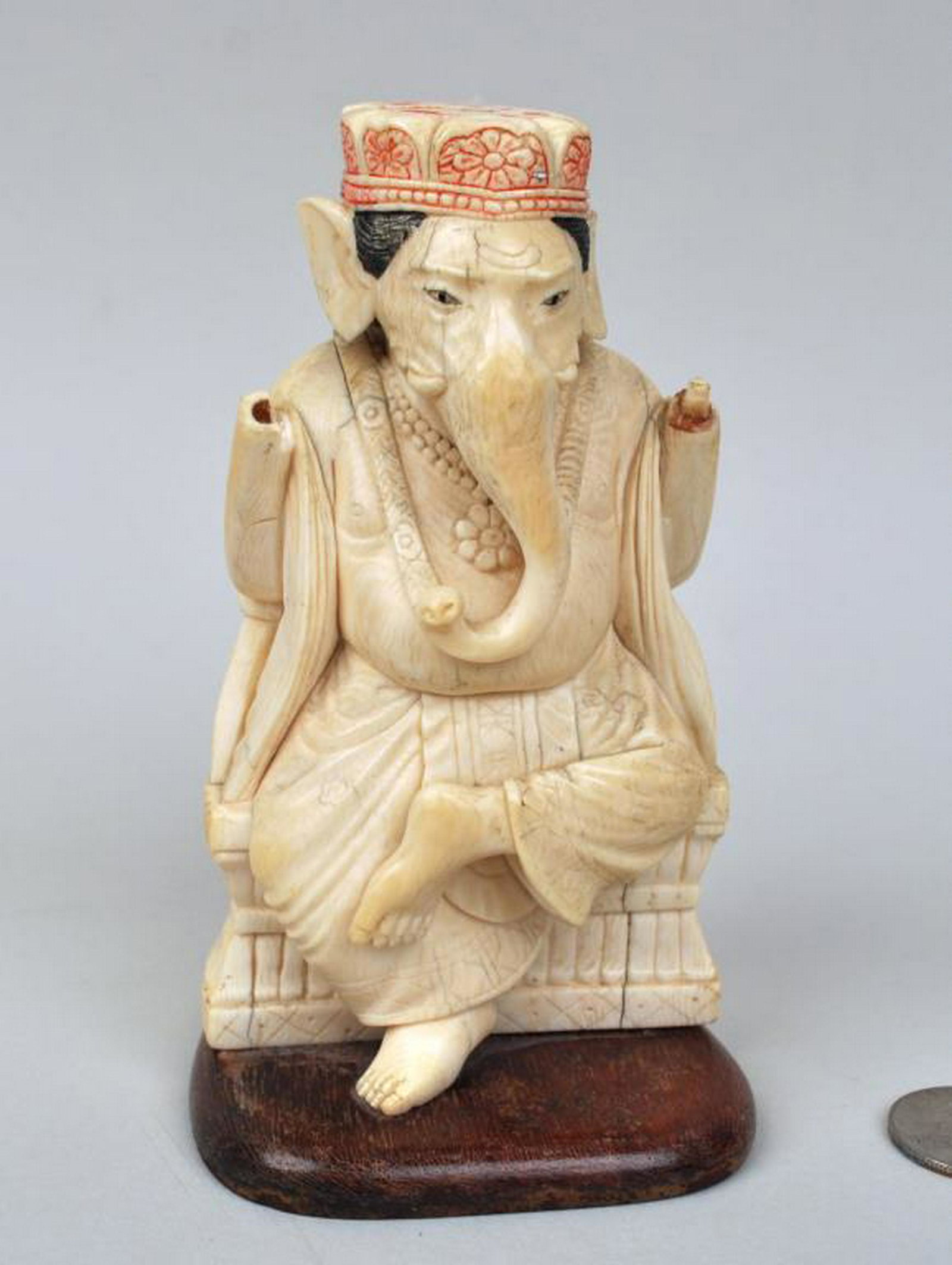 Asian Carved & Polychrome Ganesha Figure: seated on a carved throne,the incised detail heightened with color, on a wood base. 5" high, 3" wide, 3" deep. Losses to both arms, some surface staining/discoloration. International clients are ineli