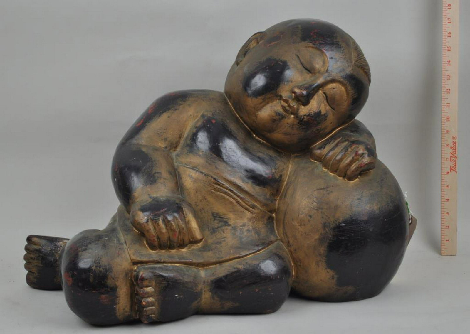 Chinese Carved Polychromed Wood Reclining Buddha: with gilt painted accents. 18" high, 24" long, 12" deep. Some minor wear and slight cracking in wood. Weight about 50 lb.