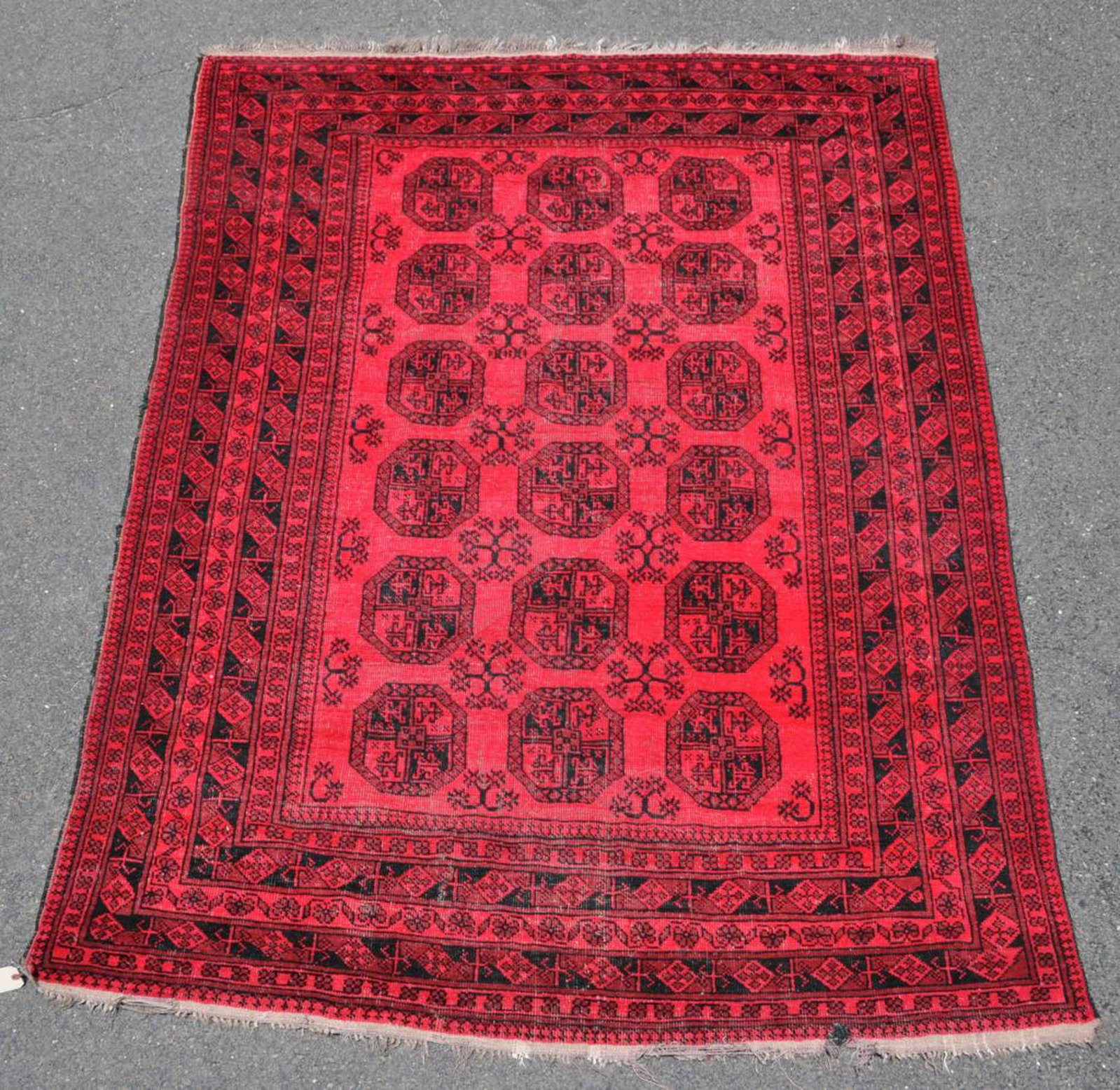 Afghan Room Size Rug: in red/rust tones, 9' 6" by 6' 2", with fray hole in end border and visible wear in field. All rugs sold as is.