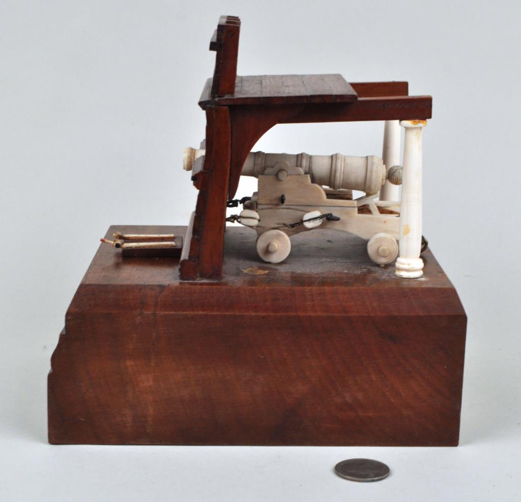 Miniature Ship's Cannon Model: on elaborate wood "hull" stand. 7 1/2" high, 7 1/2" wide. One piece detached. Provenance: Property of a New Haven County CT Estate.