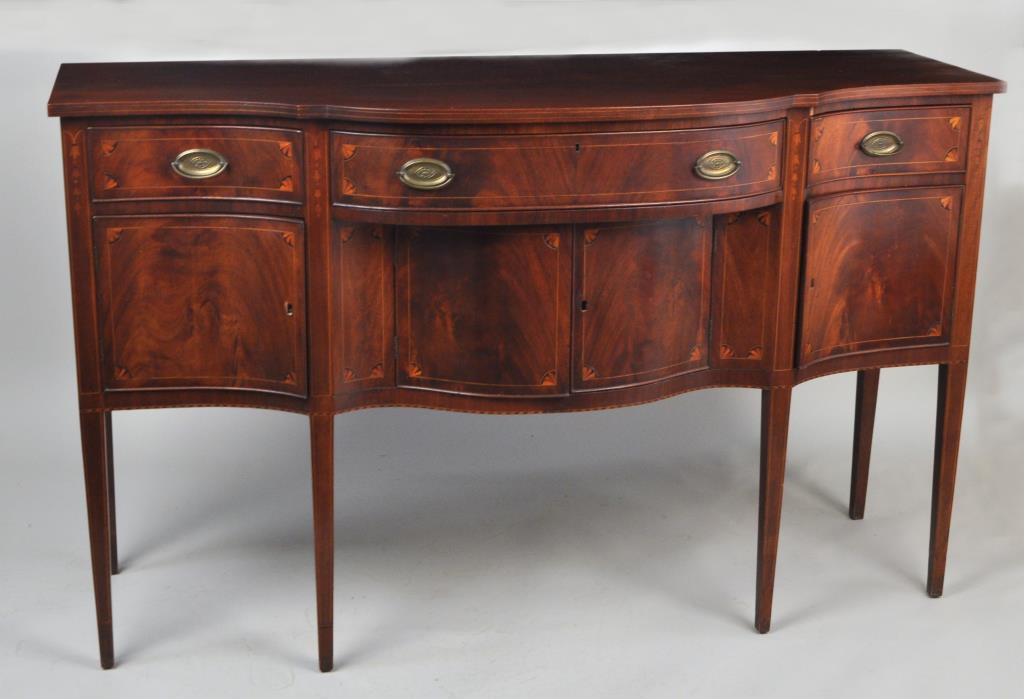 Hepplewhite Inlaid Mahogany Sideboard: late 19th century, with serpentine front. String, bellflower and fan inlays. 40" high, 65" wide, 24 1/2" deep. Scratches and wear to top.