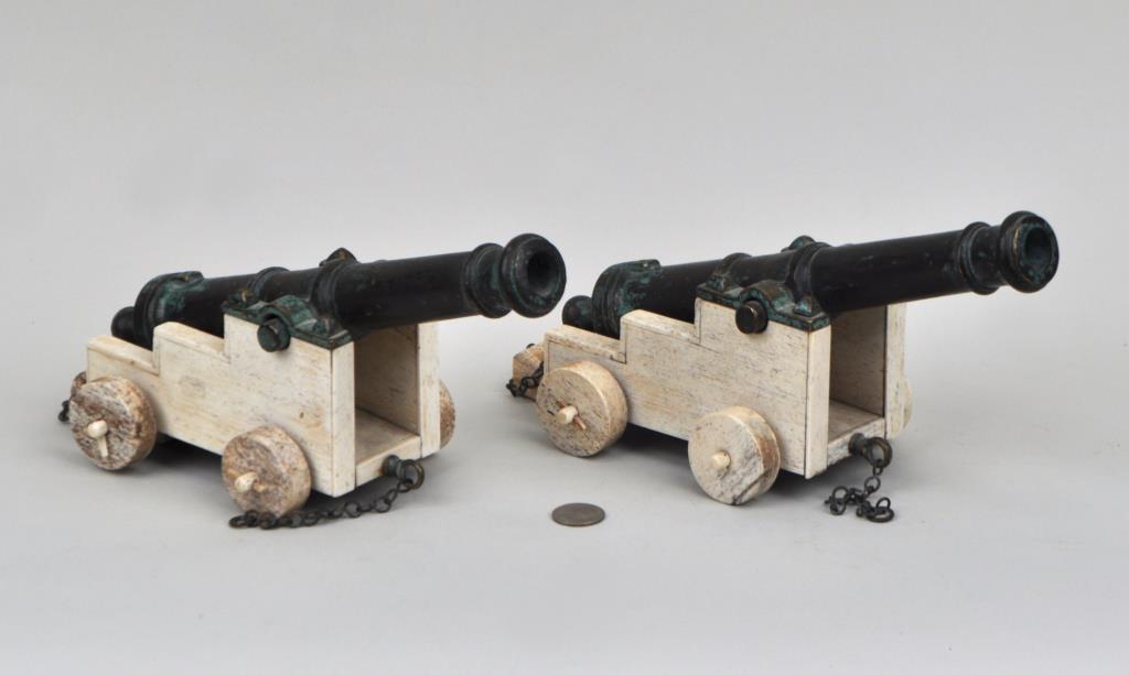 Pair Bronze & Whalebone Miniature Naval Cannons: each cast bronze cannon on whalebone carriage with chock. 6" high, 11" long, 5" wide. Showing oxidation and wear. Provenance: Property of a New Haven County CT Estate.