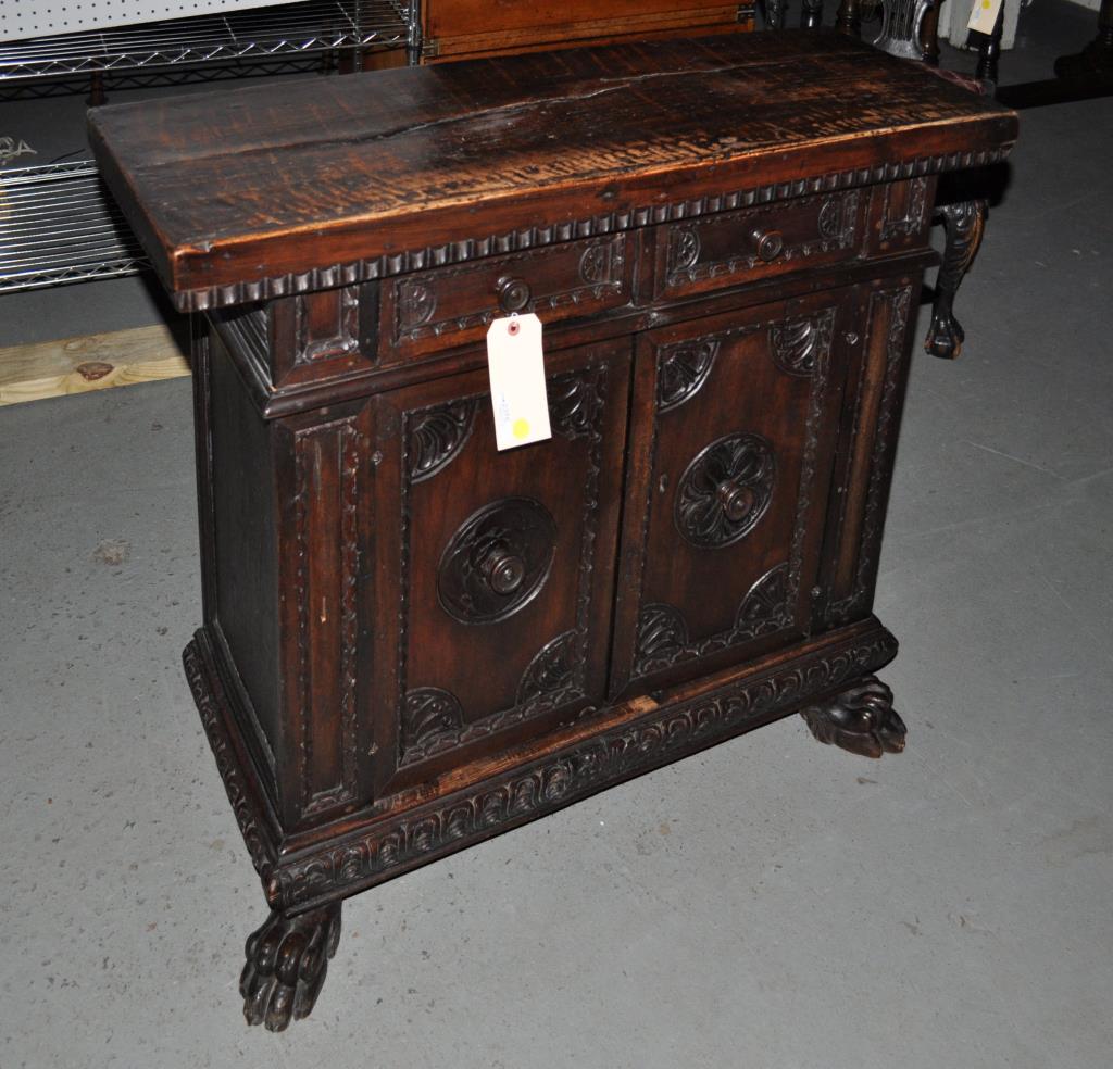 Italian Renaissance Style Carved Walnut Credenza: 34" high, 39" wide, 14" deep. Two carved drawers over a pair of cabinet doors and carved base on paw feet. Cracks and old repair to top, some losses and wear throughout.