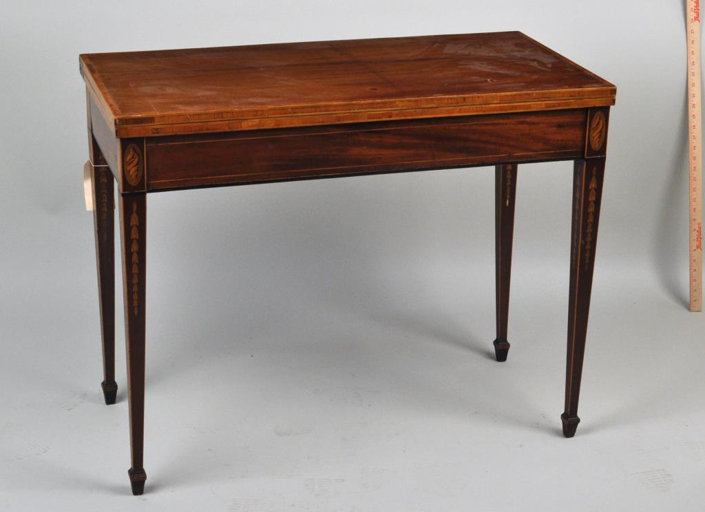 George III Inlaid Rectangular Fold Over Card Table: the legs with whelk and bellflower inlay. 29 1/2" high, 37" wide, 18 1/2" deep, 36 1/2" deep (open). Age cracks, fading, small stains to top, restoration.