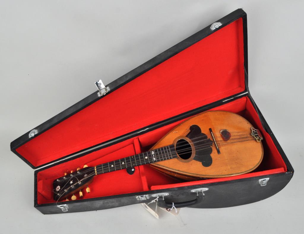 Washburn Roundback "New Model" Mandolin: 1880s George Washburn roundback "New Model" with wide stave round bowl back and MOP inlay. 25" high, 8" wide. 7" deep. Scuffing, cracks to the guard. Originally purchased and owned by Larry Marsala, a