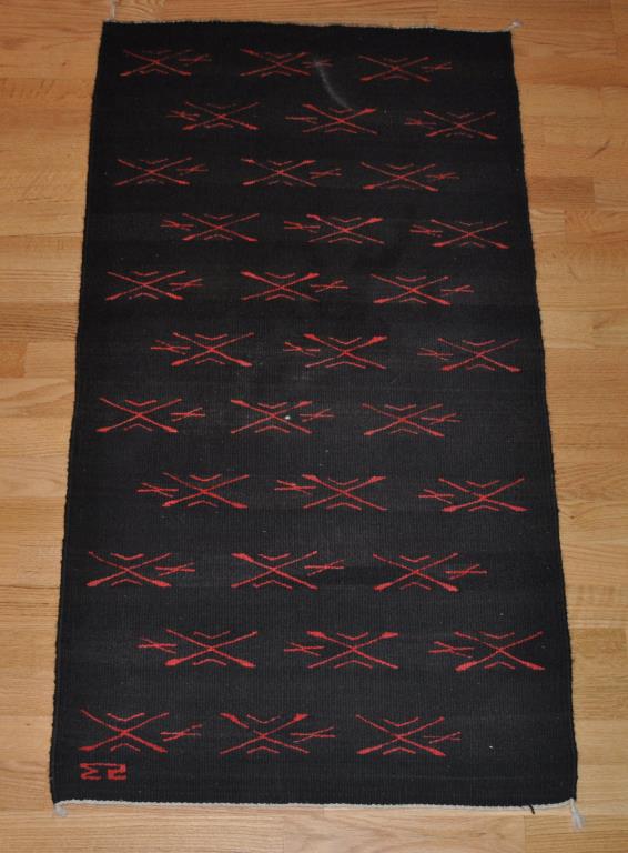 Southwestern Themed Woved Area Rug: in black background with red, signed "ES." 2' 2" wide, 4' 1" long All rugs sold as is.
