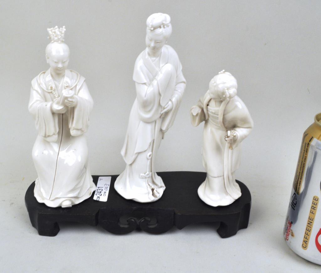Three Chinese Blanc De Chine Figures w/Stand: the largest: 6 3/4" high, 2" wide. All with small chips, losses to headdresses, one lacking hand. Provenance: Estate of Lucy Jarvis, NYC.