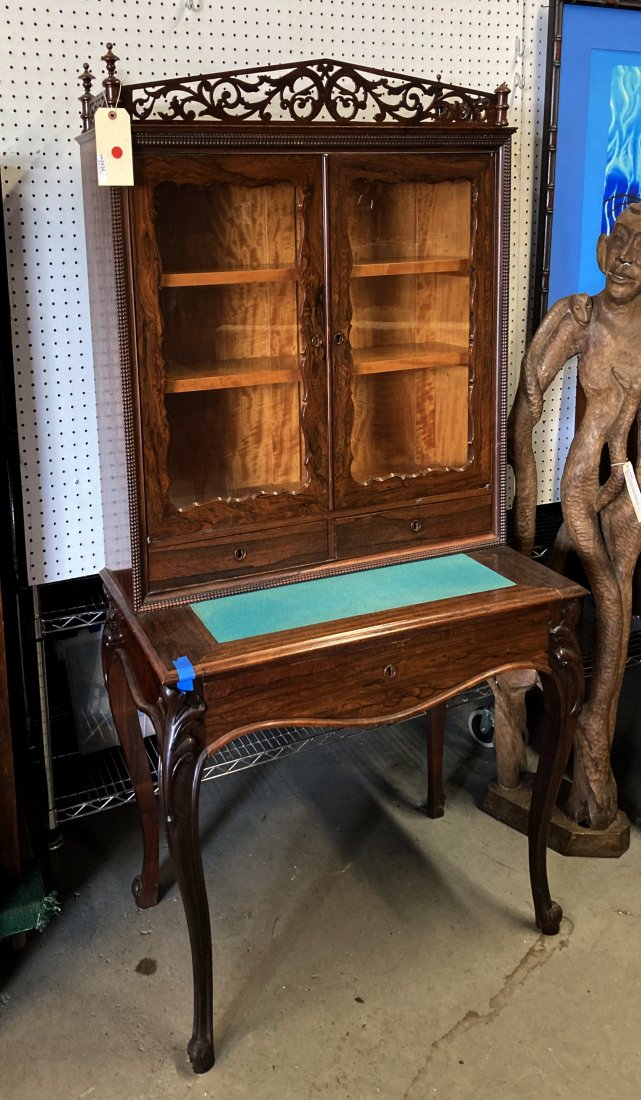 Victorian Rosewood Curio Cabinet/Stand: with pierced cornice top above glass doors and two drawers, a baize writing surface, shaped cabriole legs. Losses and repairs, cornice loose, missing finial. 66" high, 33" wide, 21" deep. Property of 