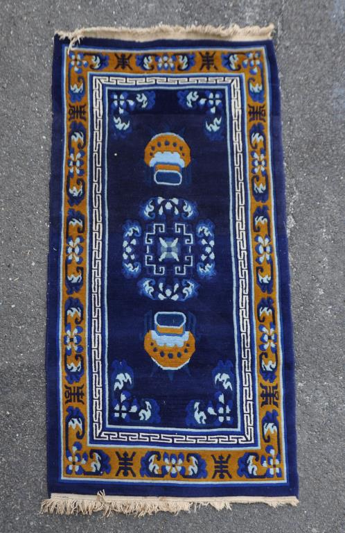 Chinese Dark Blue Ground Rug: with floral border. 6' 2" by 2' 11". Small stains to bottom fringe. All rugs sold "as is." Provenance: Estate of Lucy Jarvis, NYC.
