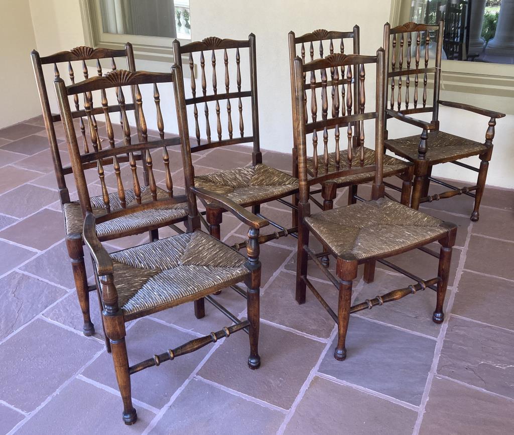 Set Six Yorkshire Style Oak Dining Chairs: comprising four side chairs and two arm chairs, rush seats. 20th century. 43" high, 21" wide, 17 1/2" deep. Age and use wear, scuffing to legs. Provenance: Greenwich CT Private Collection.