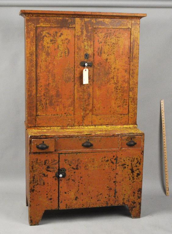 Period American Country Painted Step Back Cupboard: in two parts, upper with two doors, cubbies and shelves; lower with one door, bootjack ends; old mustard and orange paint.19th century. 67 1/2" high, 49" wide, 20" deep.. Significant chipping and loss