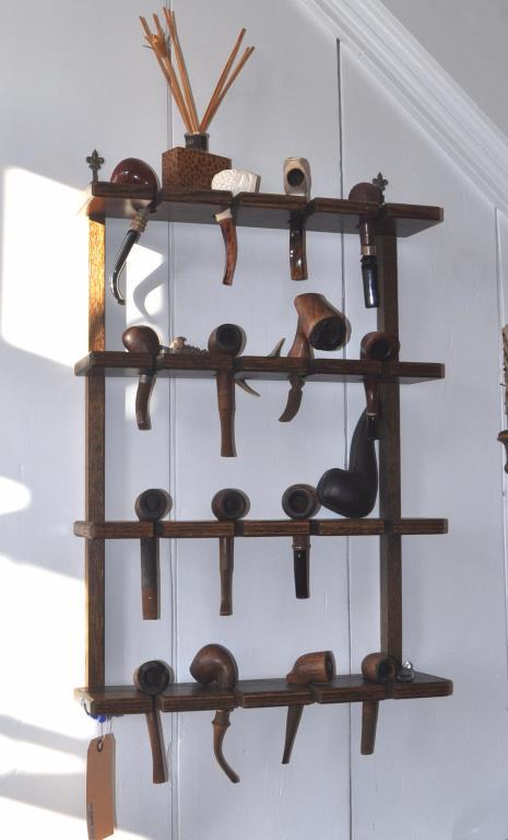 Wood Wall Pipe Rack, Pipes & Accessories: including two Meerschaum pipes and an antler cigar cutter. Largest: 25" high, 18" wide. Accessories with use wear. See photos for makers. Provenance: Shagbark Farm, Main Residence, Washington CT.