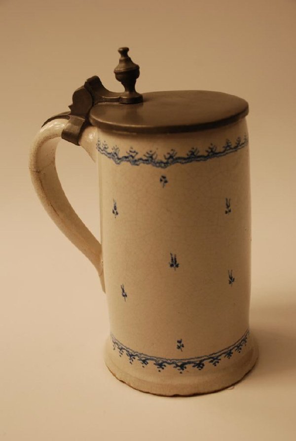 Glazed Earthenware Pewter-lidded Tankard: Blue and white glazed earthenware and pewter-lidded tankard. German, circa 1800. The inside lid inscribed "Seganskrug", and hairline cracks restored. 7 1/2" high, 5 1/2" diameter