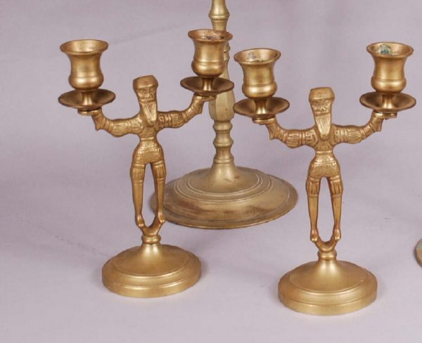 Two Pairs of Brass Candle Sticks: Two pairs of brass candle sticks. One pair of bell brass of Normandy style male figures, size 9" high, 7" wide. Second pair with mythical beast figures which stand 16" high, 14" wide. 20th C., one ben