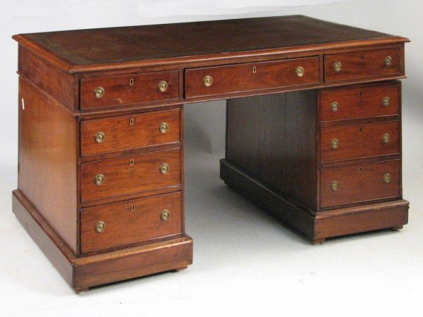 George III Partner's Desk, 19th C.: George III figured mahogany pedestal form partner's desk, with brown leather tooled top with thumb molded top edge above three drawers on each long side, set on pedestal bases with cupboard doors and 