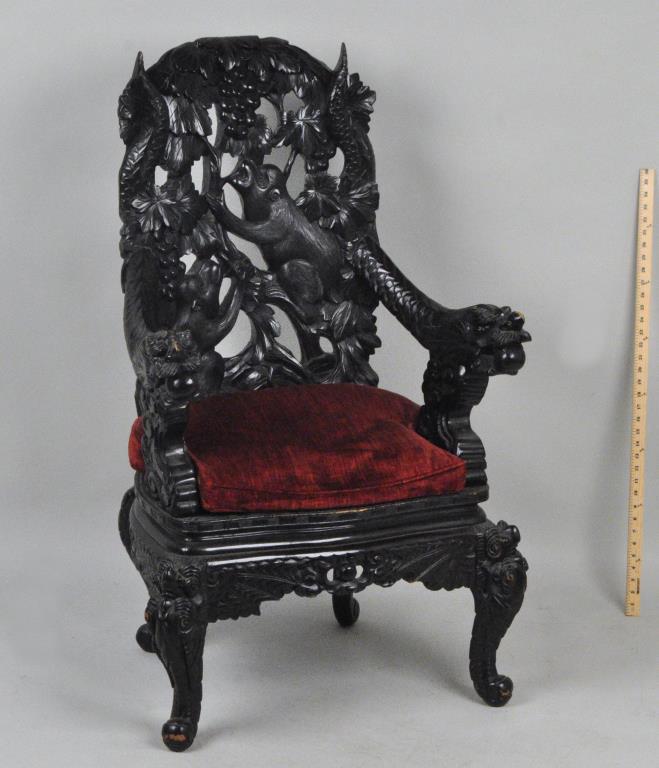 Large Chinese Carved Hardwood Arm Chair: high back with carved monkey, fruit and foliage, with dragon carved arms. 46" high, 27" wide, 21" deep. Small abrasions and losses to carved detail. Provenance: Property of a New Haven County Collecto