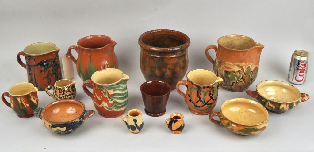 Group French Jasper Glazed Country Pottery: comprising nine pitchers, three porringers and two urns. Largest: 7 1/2" high, 7 1/4" wide. Some wear, stains and chips. Provenance: Property of a New York City Collector.