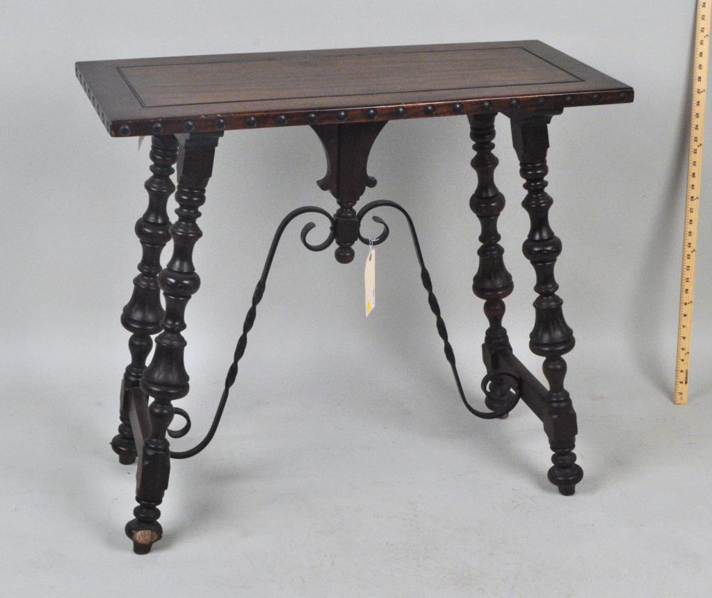 Spanish Baroque Style Wood/Iron Side Table: paneled mahogany top on turned and carved splayed legs with iron supports. 32" high, 35 3/4" wide, 15 3/4" deep. Small scratches to top edges, light wear to base. Provenance: Property of a New Haven C