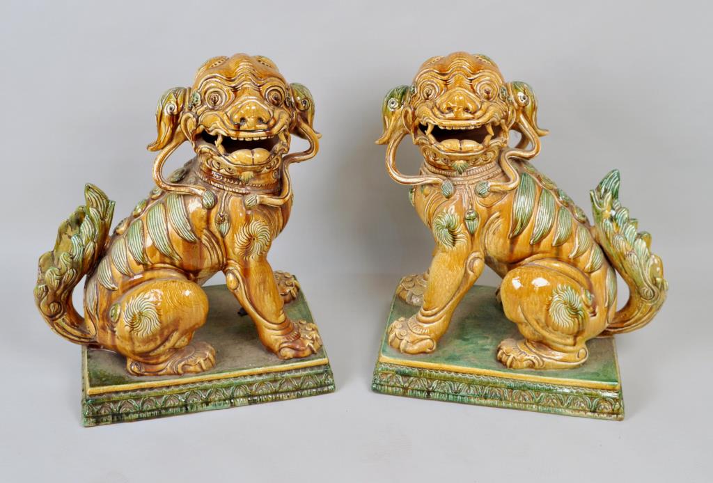 Pair Large Chinese Style Majolica Pottery Foo Dogs: each seated on a stepped plinth base, sancai toned glaze, Italian manufacture. 27" high, 21" wide, 14 1/2" deep. Loss to one claw and connecting swag. Provenance: Property of a New Haven County Collec