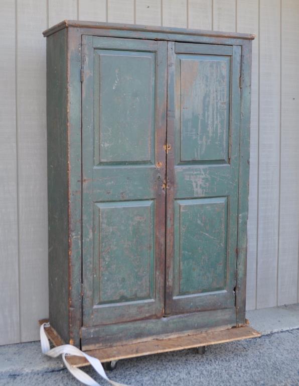 Country/Primitive American Wall Cupboard: in green paint, with two vertical paneled doors, plinth base. 71" high, 45" wide, 18" deep. Paint loss, loss to moldings and base moldings, some repairs and restorations to base. Provenance: Property 