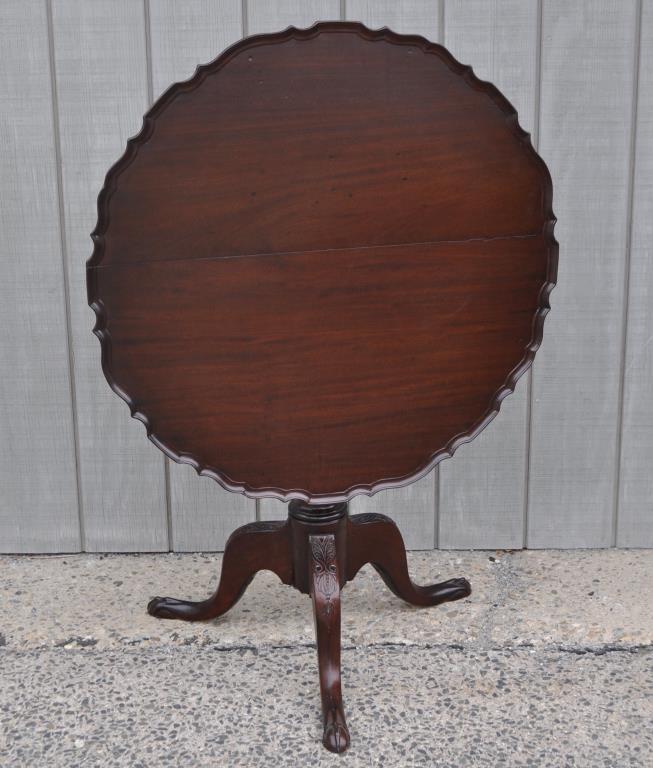 Georgian Carved Mahogany Pie Crust Tea Table: two board scalloped edge top, carved urn column and carved cabriole legs and feet. 28 1/2" high, 33 1/2" diameter. Some restorations, repairs to top, finish restorations.