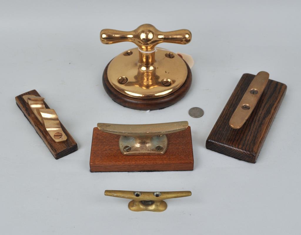 Group Five Brass Ship's Dock Cleats: four mounted on wooden plaques. Largest: 4 1/4" high, 6" diameter. Provenance: Estate of George E. Ratcliffe, Darien, CT. We offer in-house packing and shipping of this item to an address in the Unite