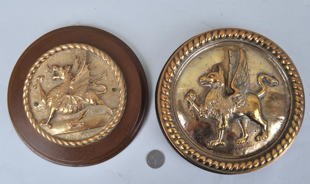Two Bronze Ship's Badges: Welsh dragon on a Bakelite backing "HMS Caradoc" & a Griffon on wooden backing (likely HMS Revenge). Largest: 7 1/2" diameter. Provenance: Estate of George E. Ratcliffe, Darien, CT. We offer in-house 