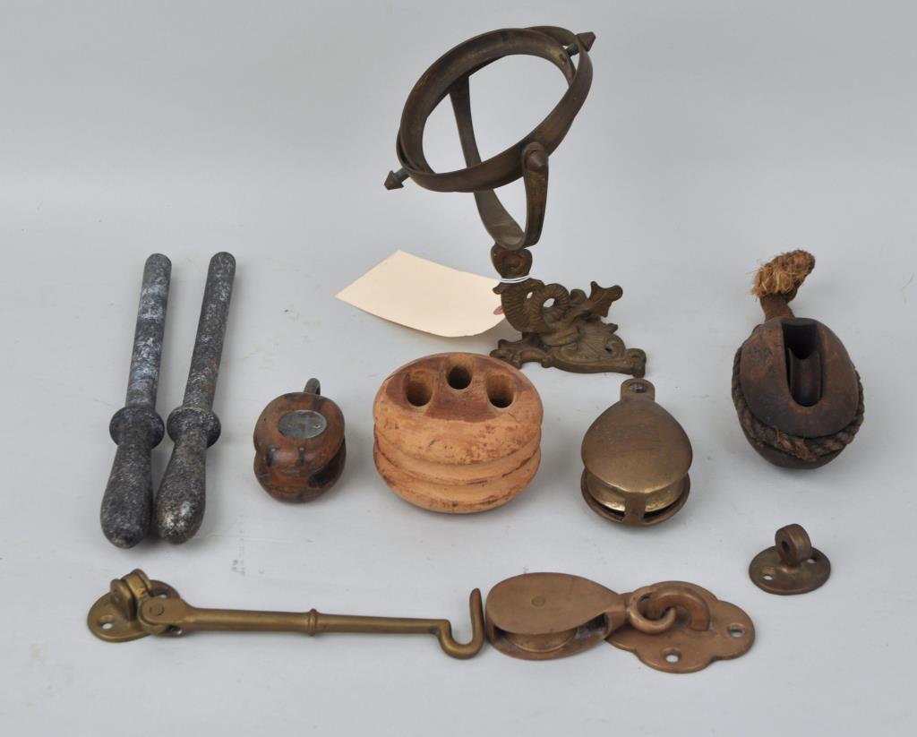 Group Nine Assorted Ship's Accessories: comprising pulleys and others, including a dolphin wall mount for a lamp, 2 small brass pulleys. Largest: 3 1/4" high, 9" wide. Use wear, surface wear, soiling, age cracks to one of the wood pulleys. 