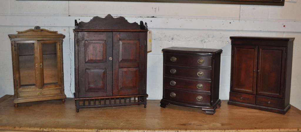 Four Antique/Vintage Miniature Furniture Items: comprising a miniature armoire with glass doors, Victorian style cabinet, cabinet with two doors and a Bombay Co. bow front chest fitted as a jewelry box. Largest: 22 3/8" high, 17 1/8" long, 6" deep.